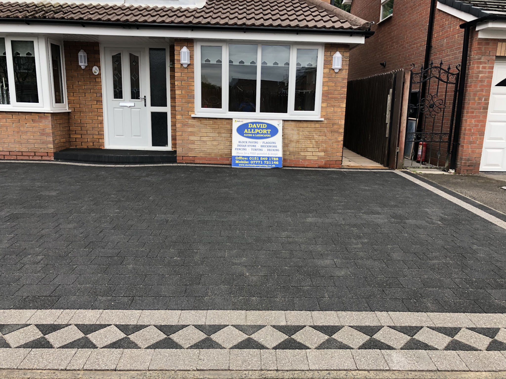A charcoal block-paved driveway with a diamond-pattern border in front of a bungalow